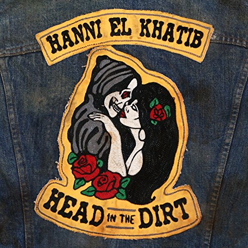 The image shows a denim jacket with an embroidered patch. Here is a possible alt text: "Denim jacket with embroidered patch featuring a woman and skeleton embracing."