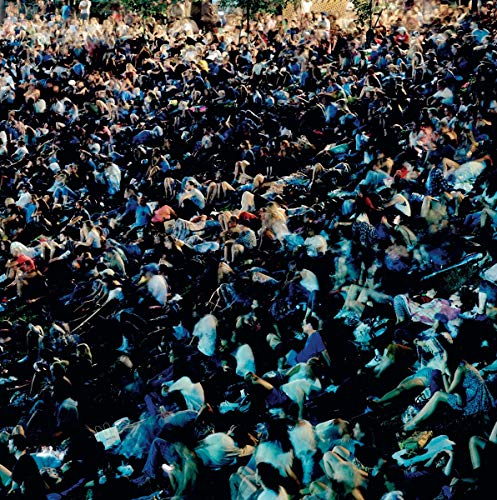 A dense crowd of people, mostly shirtless, gathered together in a chaotic scene.