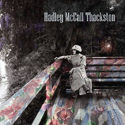 "CD cover featuring a woman in white sitting on a floral-painted bridge."