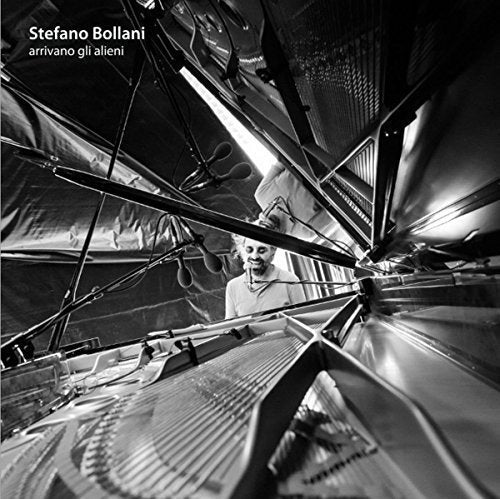 "Black and white album cover with man surrounded by metal structure and microphone."