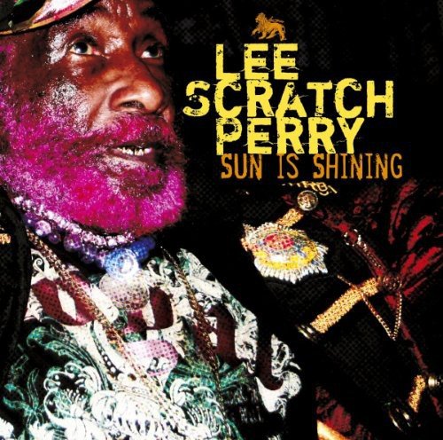 Album cover with Lee Scratch Perry wearing ornate clothing and jewelry against a dark background.