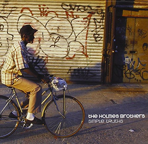 "Album cover with man riding bicycle in front of graffiti-covered metal shutter door."
