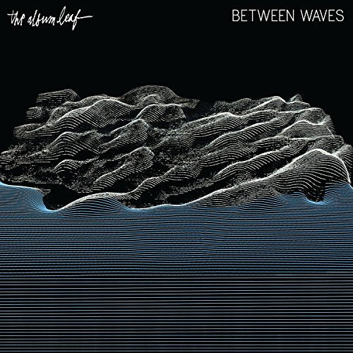 The image depicts the album cover for "Between Waves" by The Album Leaf. The alt text for this image could be: "Black album cover with white waves and 'Between Waves' text."