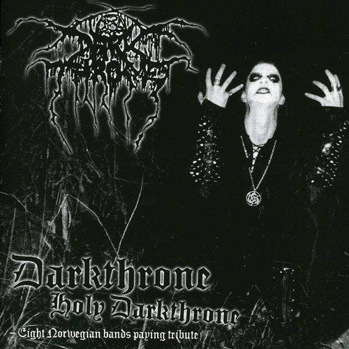"Black and white album cover with a man in dark attire and hands raised."