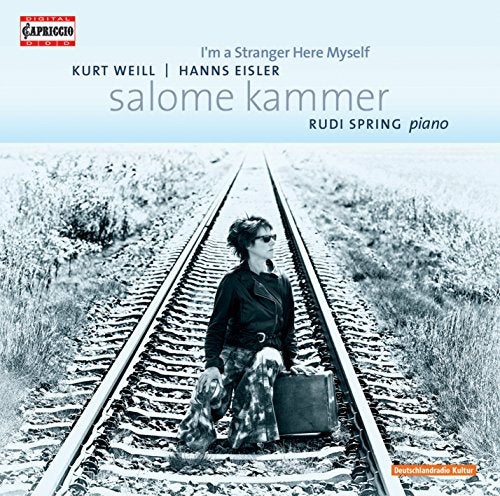 CD cover with a woman sitting on train tracks, holding a suitcase, in black and white.