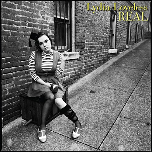 Black and white album cover with a woman sitting on a crate outdoors.