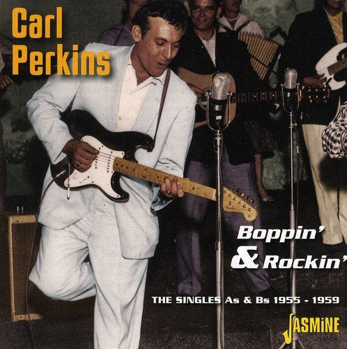 Carl Perkins CD cover: man in white suit playing guitar on stage with band.