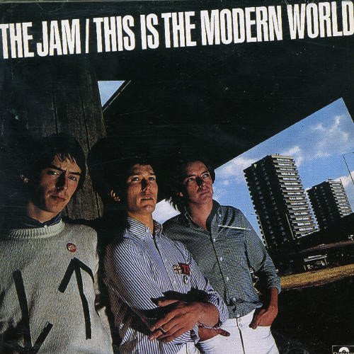 "The Jam album cover with three band members standing under a cityscape."
