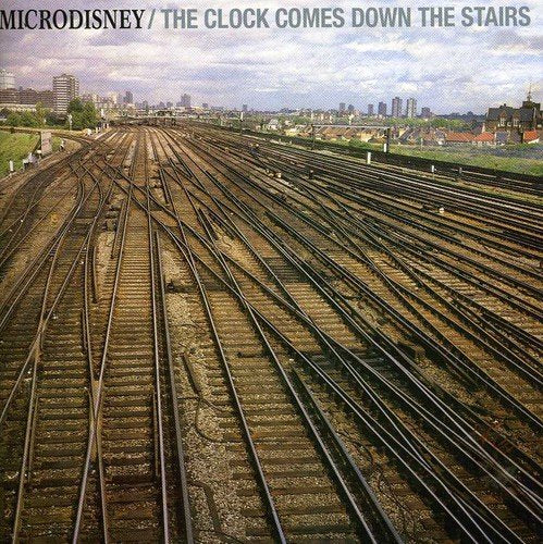 "Album cover featuring multiple train tracks converging, with cityscape in the background."