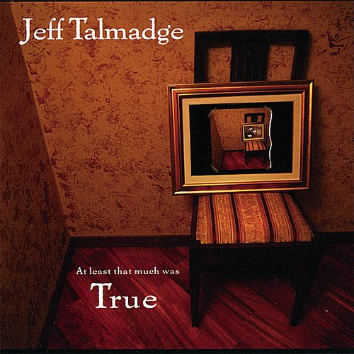 "Album cover with a chair holding a framed picture, against a patterned wall."