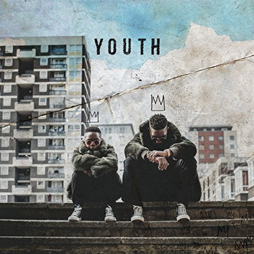 "Album cover with two men crouching on steps, cityscape in the background."