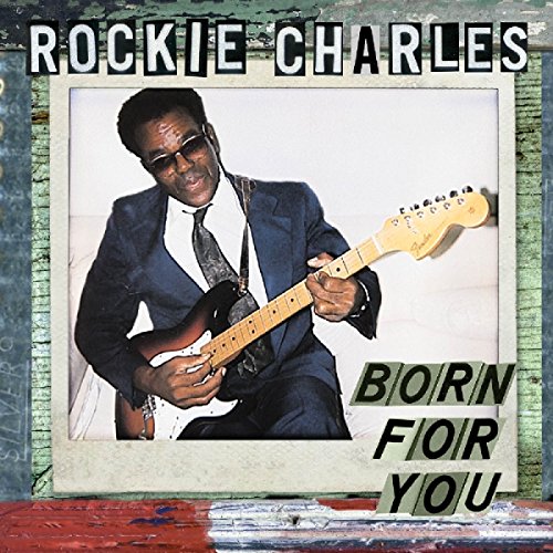"Album cover with Rockie Charles playing an electric guitar, wearing a blue suit."