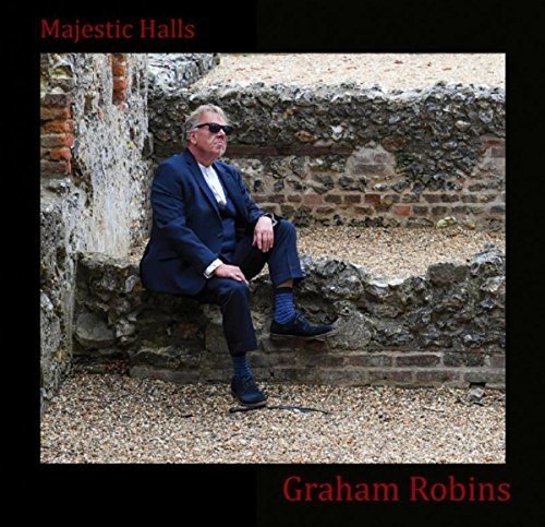 "Album cover with a man in a suit sitting on a stone wall."