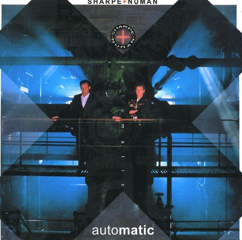 "Album cover with two men standing on a metal platform, blue-lit industrial background."