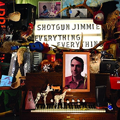 "Album cover with eclectic collage, piano, and framed portrait of a man."