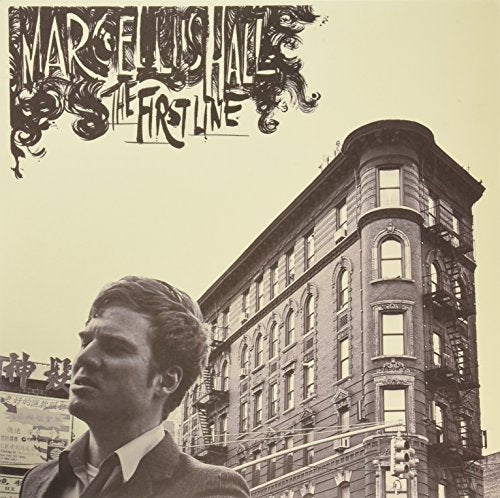 "Album cover featuring a man in a suit and a tall building."