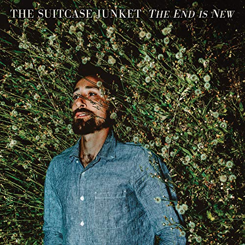 Man in blue shirt surrounded by flowers, album cover artwork for "The Suitcase Junket".