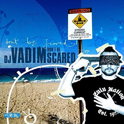 "Album cover with a man wearing a bandana, holding a gun, on a beach background."