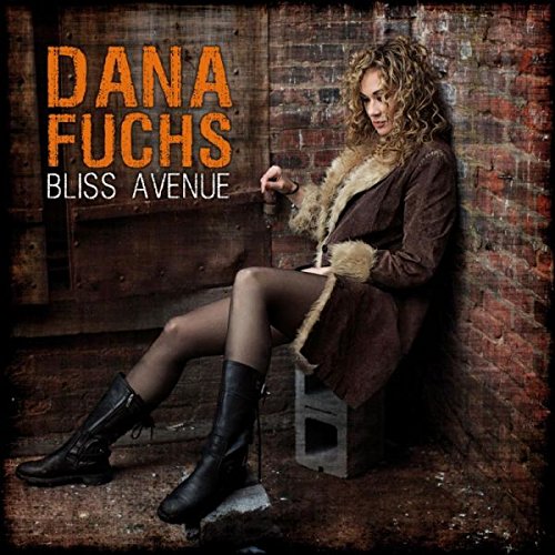 "Album cover featuring a woman sitting on a cinder block against a brick wall."