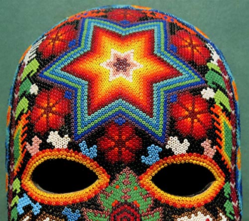 "Colourful beaded mask with star pattern on a green background."