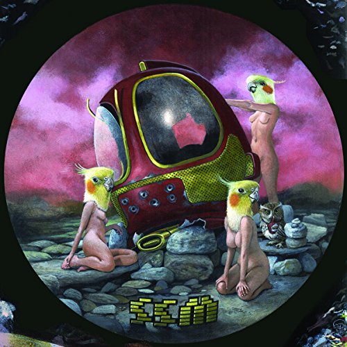 Album cover with three nude figures and cockatiels around a red spaceship on rocky terrain.