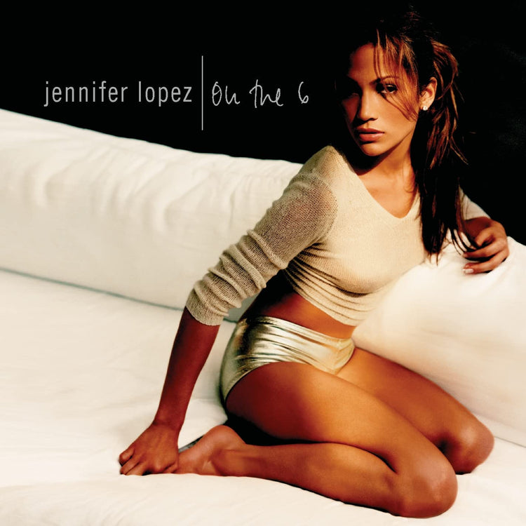 Jennifer Lopez album cover with peach vinyl records, featuring Lopez kneeling on a bed.