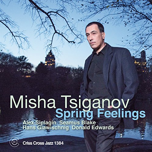 "Album cover featuring a man in a suit standing by a body of water."