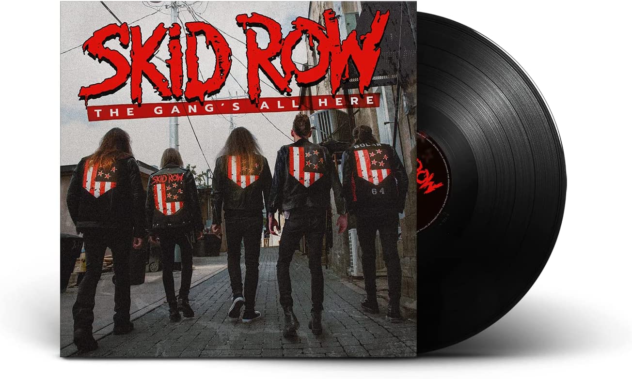 "Vinyl record with album cover featuring band members in black jackets on a city street."