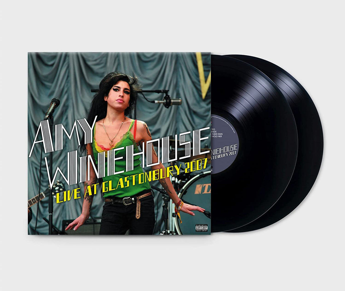 Amy Winehouse on stage, wearing a green top, with superimposed text and a microphone.