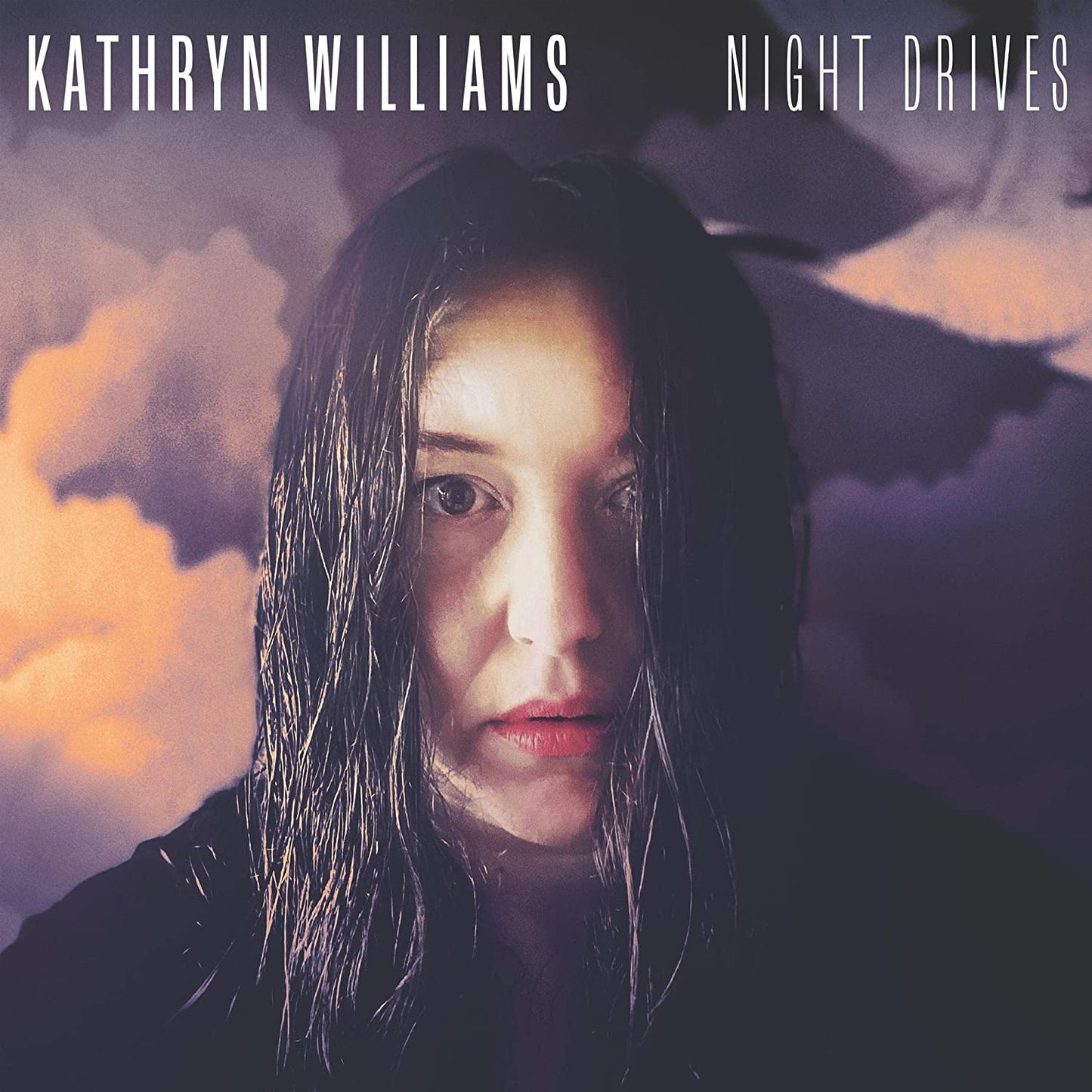"Album cover featuring a woman with wet hair against a cloudy sky."