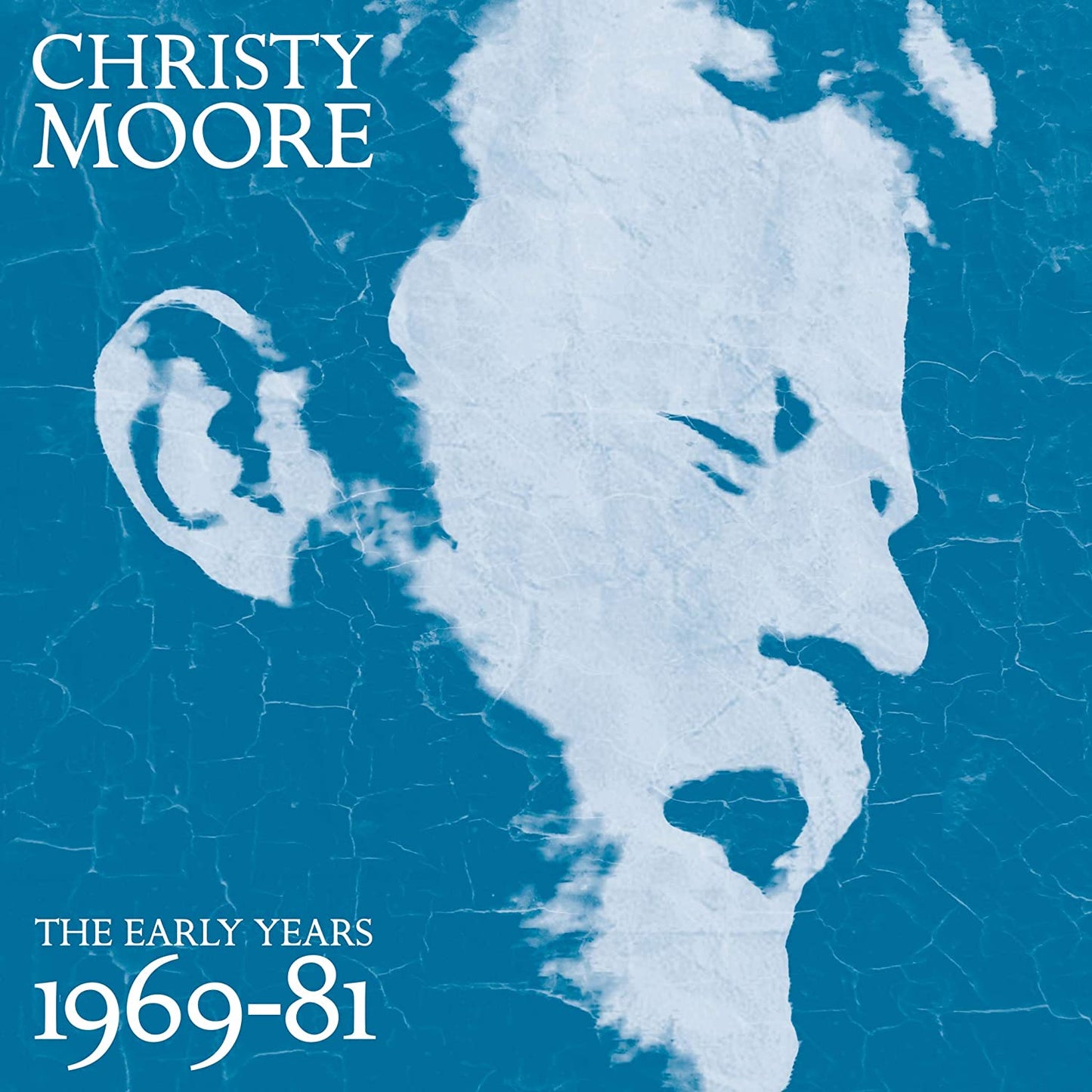 Christy Moore album cover featuring a close-up of a man's face in white on cracked black background.
