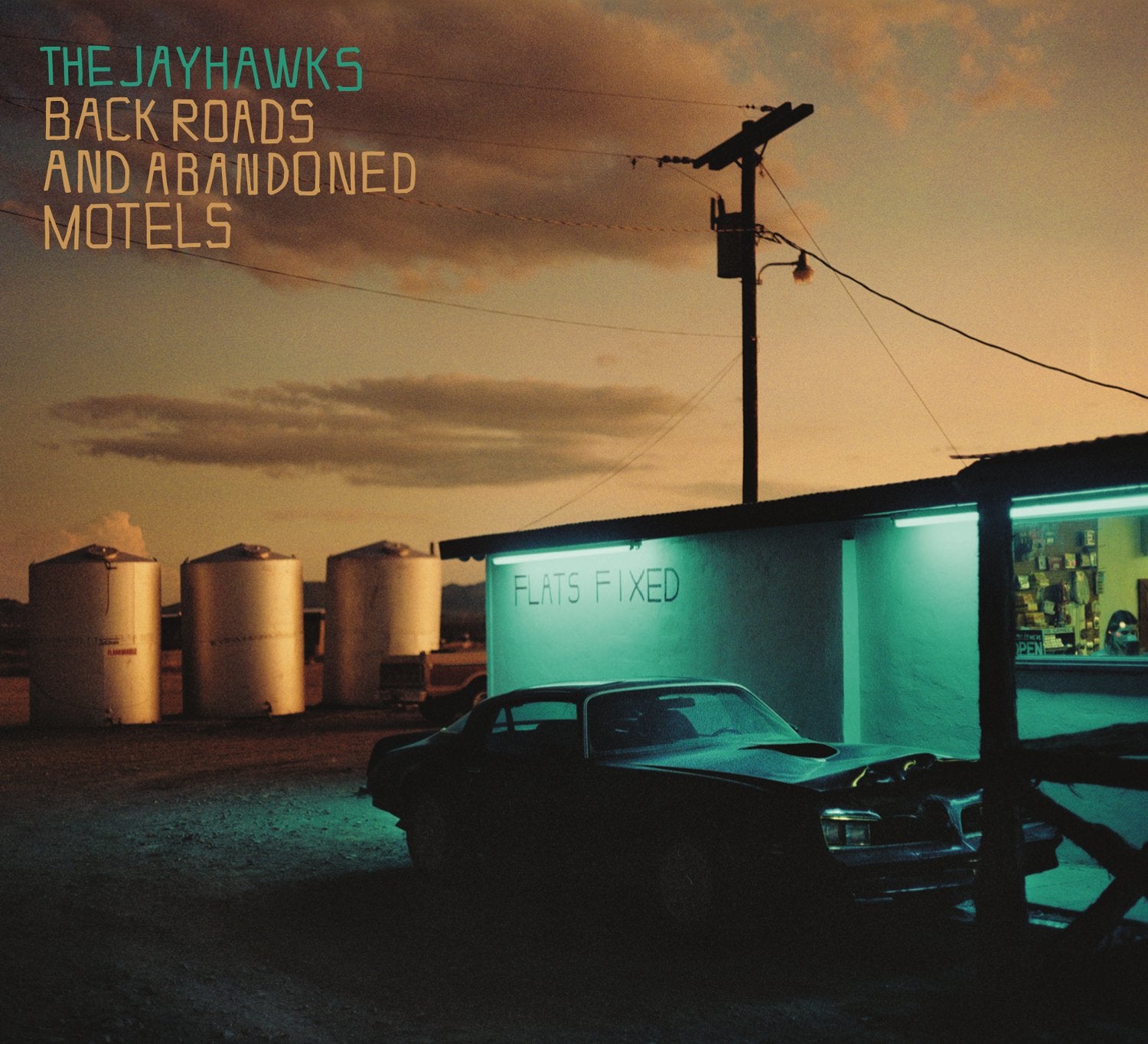 "Album cover: 'Back Roads and Abandoned Motels' by The Jayhawks, featuring a motel scene."