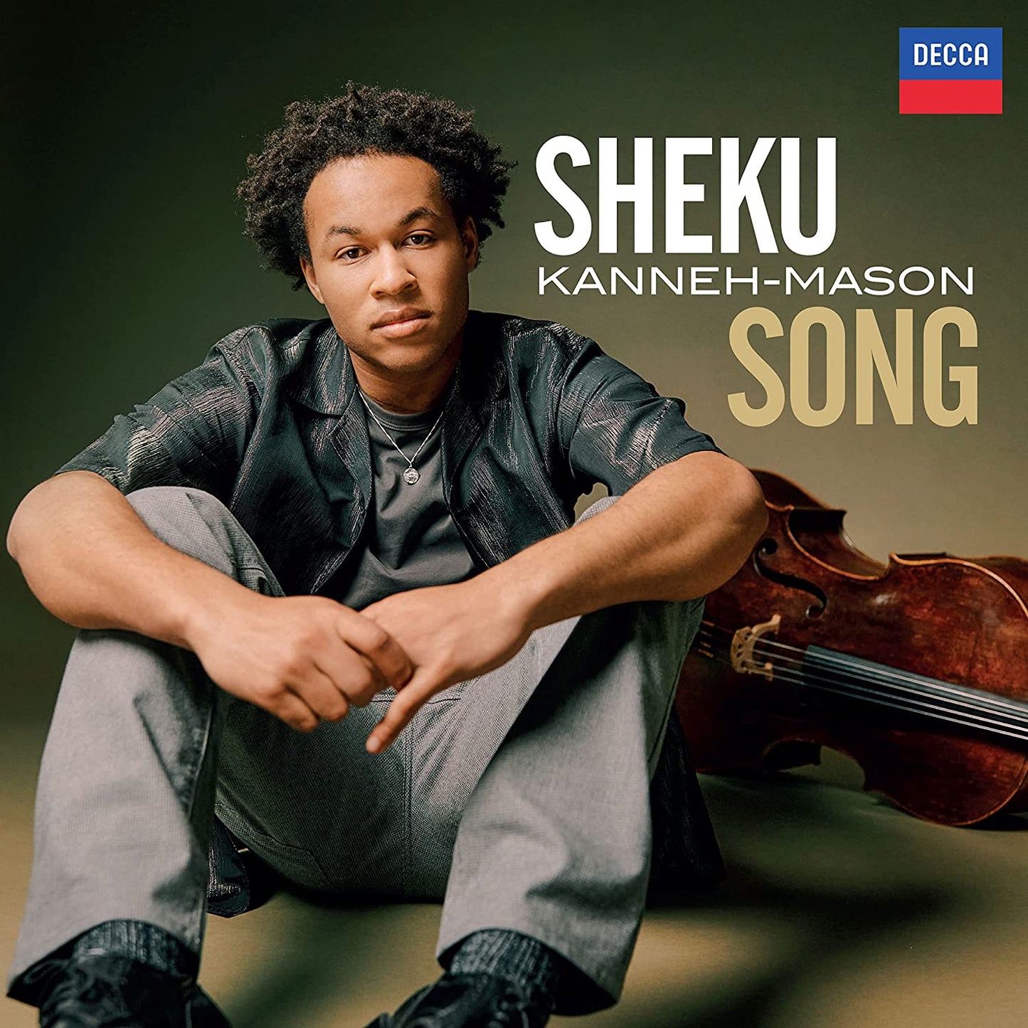 "CD cover featuring Sheku Kanneh-Mason sitting with a cello, casual attire, dark background."
