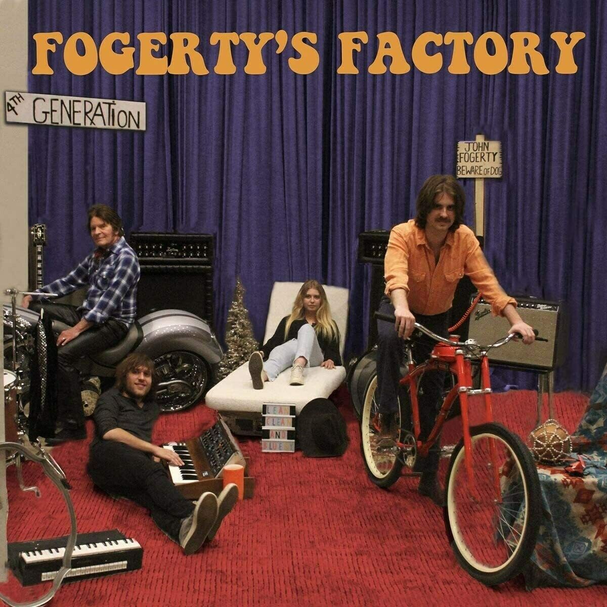 "CD cover featuring John Fogerty and band, with musical equipment and bicycles on a red carpet."